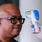 Dr. Chikwe Ihekweazu, the Director General of NCDC has his temperature checked during a diplomatic meeting at the Ministry of Foreign Affairs in Abuja