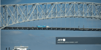 A cargo ship passes below the Francis Scott Key Bridge while leaving the Port of Baltimore October 14, 2021, in Baltimore, Maryland.