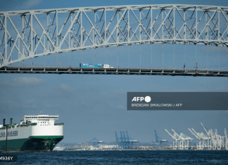 A cargo ship passes below the Francis Scott Key Bridge while leaving the Port of Baltimore October 14, 2021, in Baltimore, Maryland.